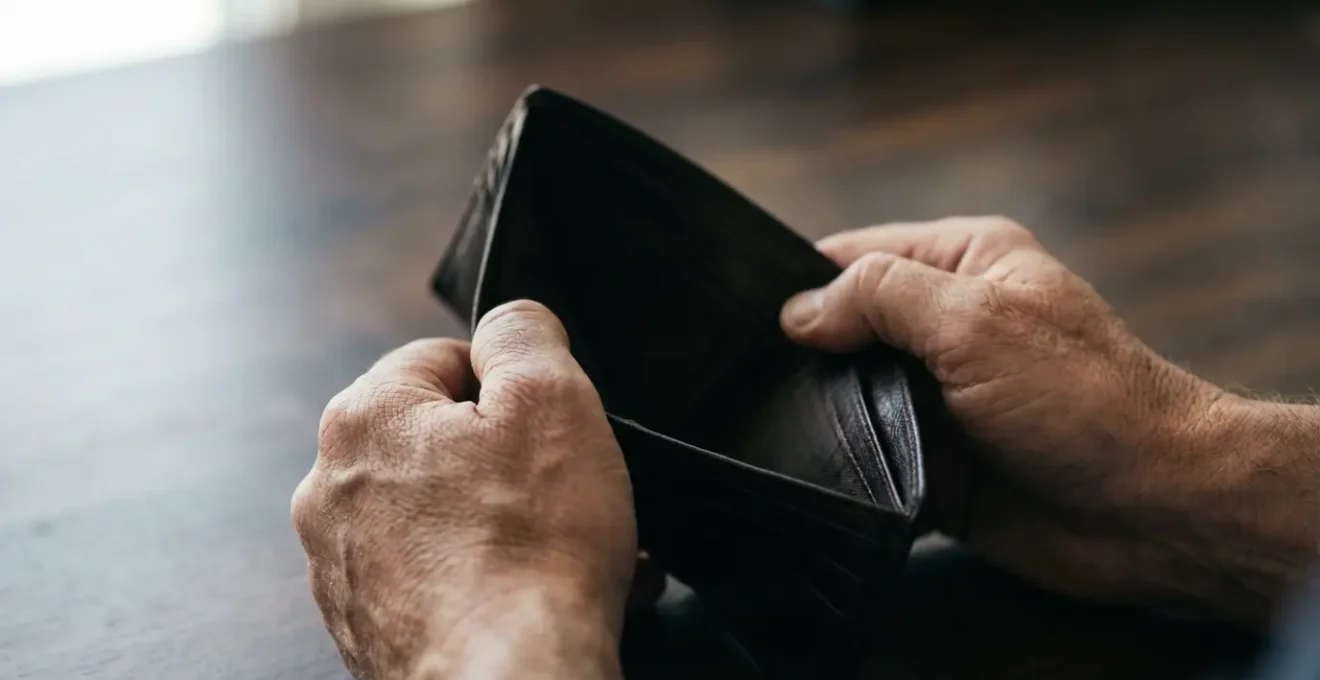 Représentation métaphorique d'une erreur contractuelle avec impact financier, montrant des mains crispées sur un portefeuille vide.