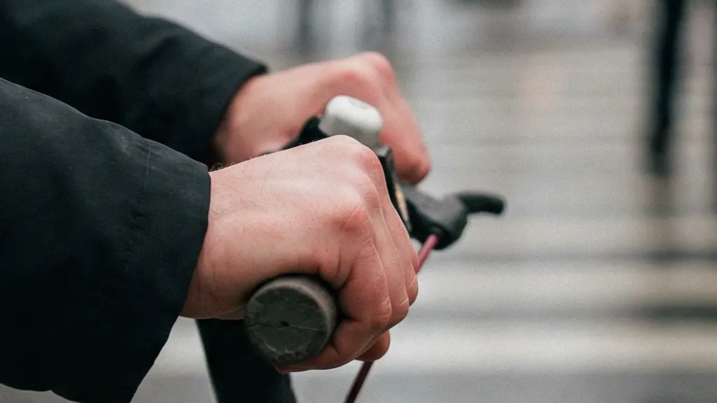 Main humaine serrant nerveusement un guidon de trottinette, symbolisant le stress lié au risque financier en cas d'accident sans assurance