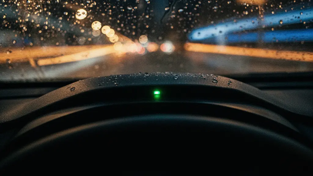 Reflet lumineux d'un tableau de bord automobile la nuit avec des traînées de lumière sur une route, évoquant l'attente technologique du suivi GPS